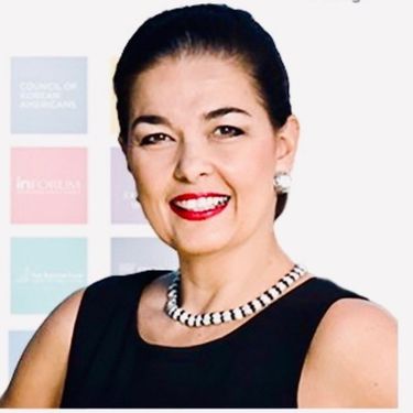 Headshot of Ana Dutra smiling, wearing a black sleeveless top and a necklace.