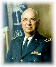 Portrait of a U.S. Army officer in dress uniform standing in front of flags.