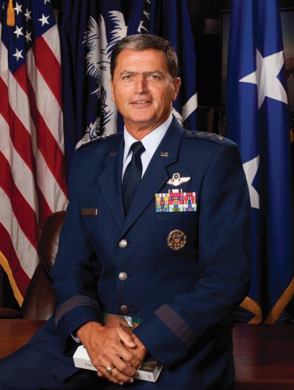 Portrait of a U.S. Air Force general in dress uniform seated in front of American and South Carolina flags.