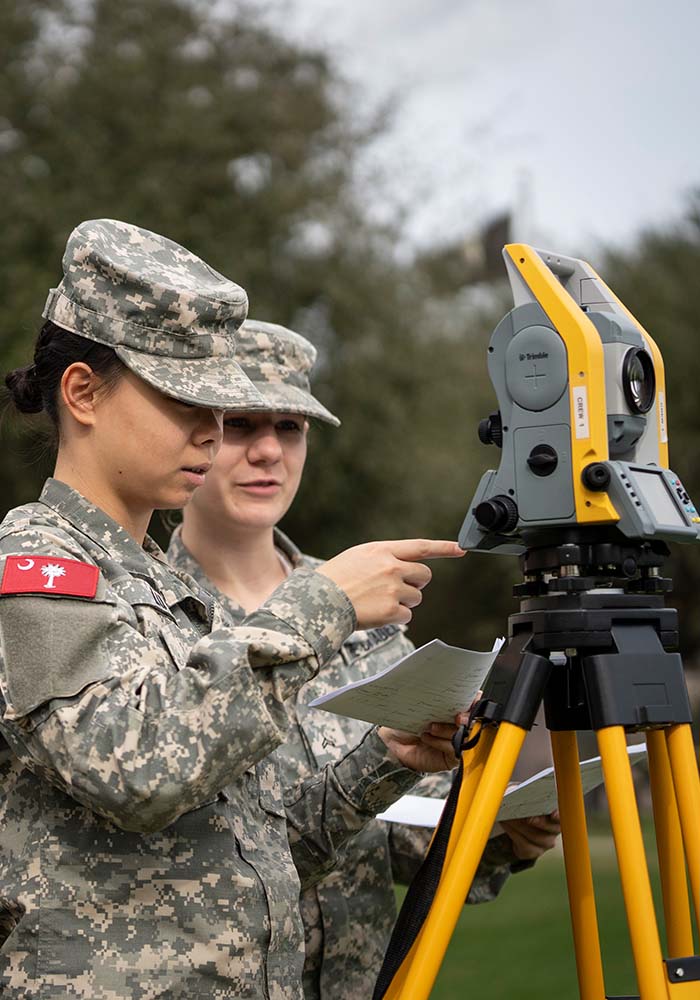 Two female cadets having hands on outdoor classroom experiences