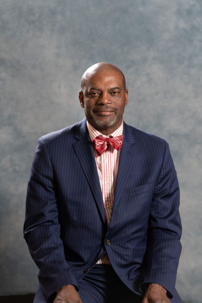 Portrait of a Melvin C Williams in a suit with a red bow tie, facing the camera against a neutral background.
