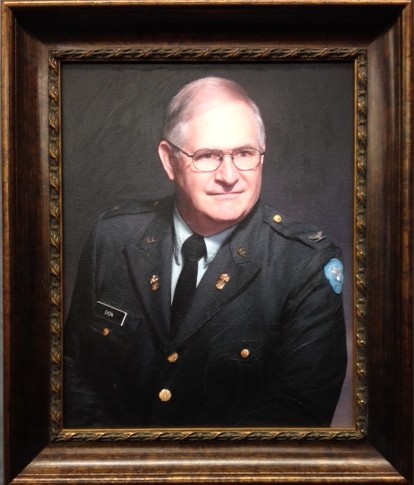 Framed painted portrait of Thomas Dion in a dark military uniform, set against a dark background.