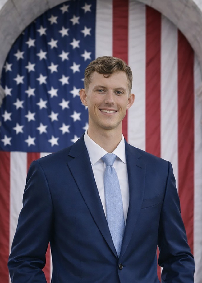 Jaret Price standing in front of an American Flag