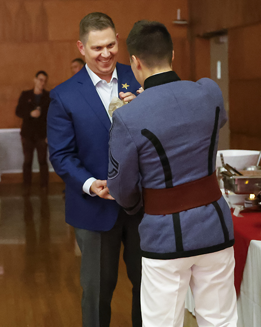 Luke Frazier gives raffle prize to a faculty member.