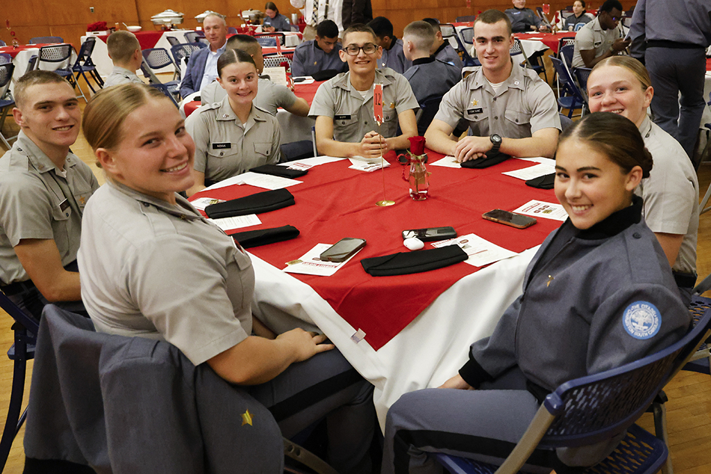 Cadets smiling at their table