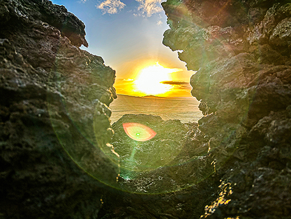 image of the sun through rocks