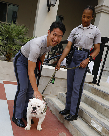Bullseye (dog) and two people posed