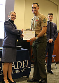 Sierra Morris presenting SSgt. Isaac Lamberth with his Certificate of Publication.