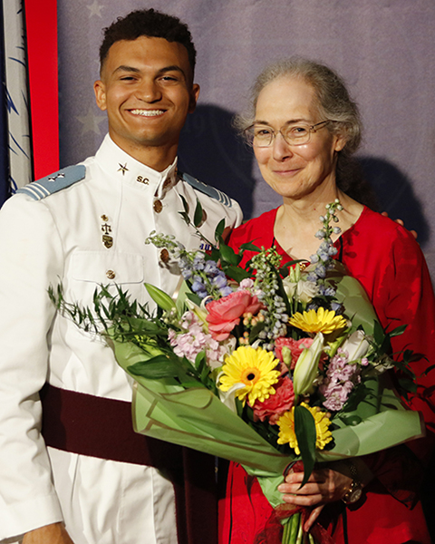 Noah Miller and Dr. Mabrouk. Dr. Mabrouk is holding flowers.