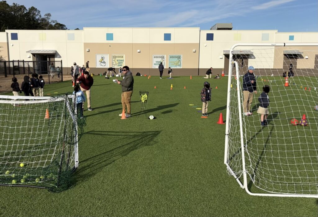 Students and researchers conducting motor skill assessments with children on an outdoor field.