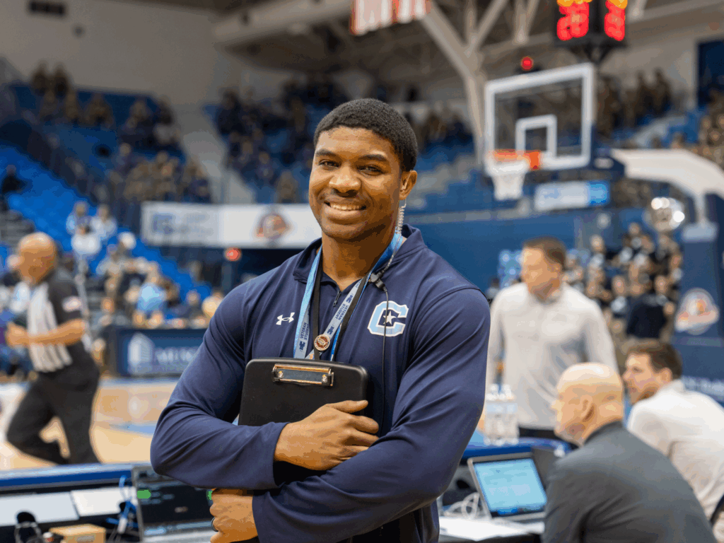 Sport management graduate smiling at The Citadel basketball game.