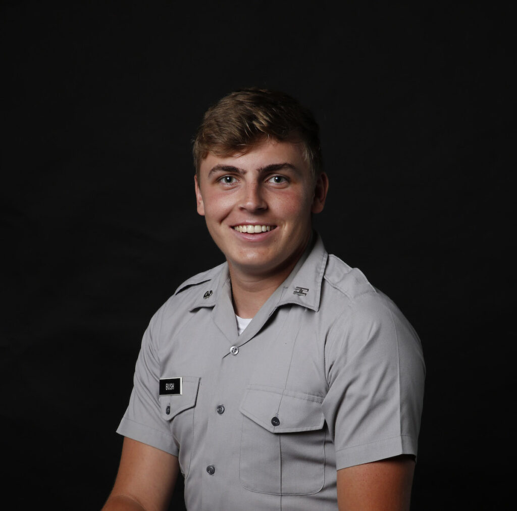 Smiling Citadel cadet Bush in a gray uniform posed against a black background.