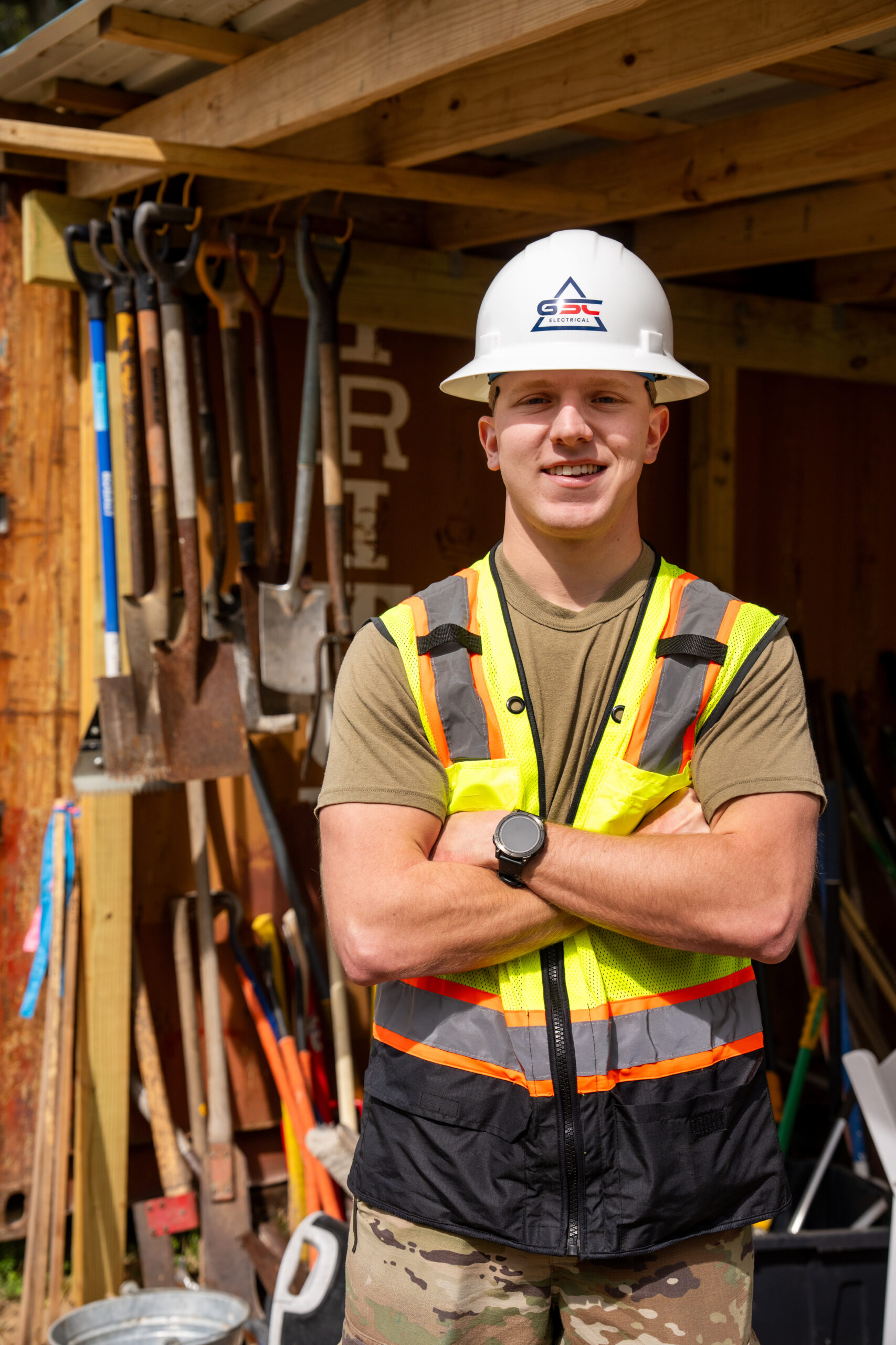 Cadet Thompson wears a hard hat and safety vest while standing at a construction site during an engineering internship.
