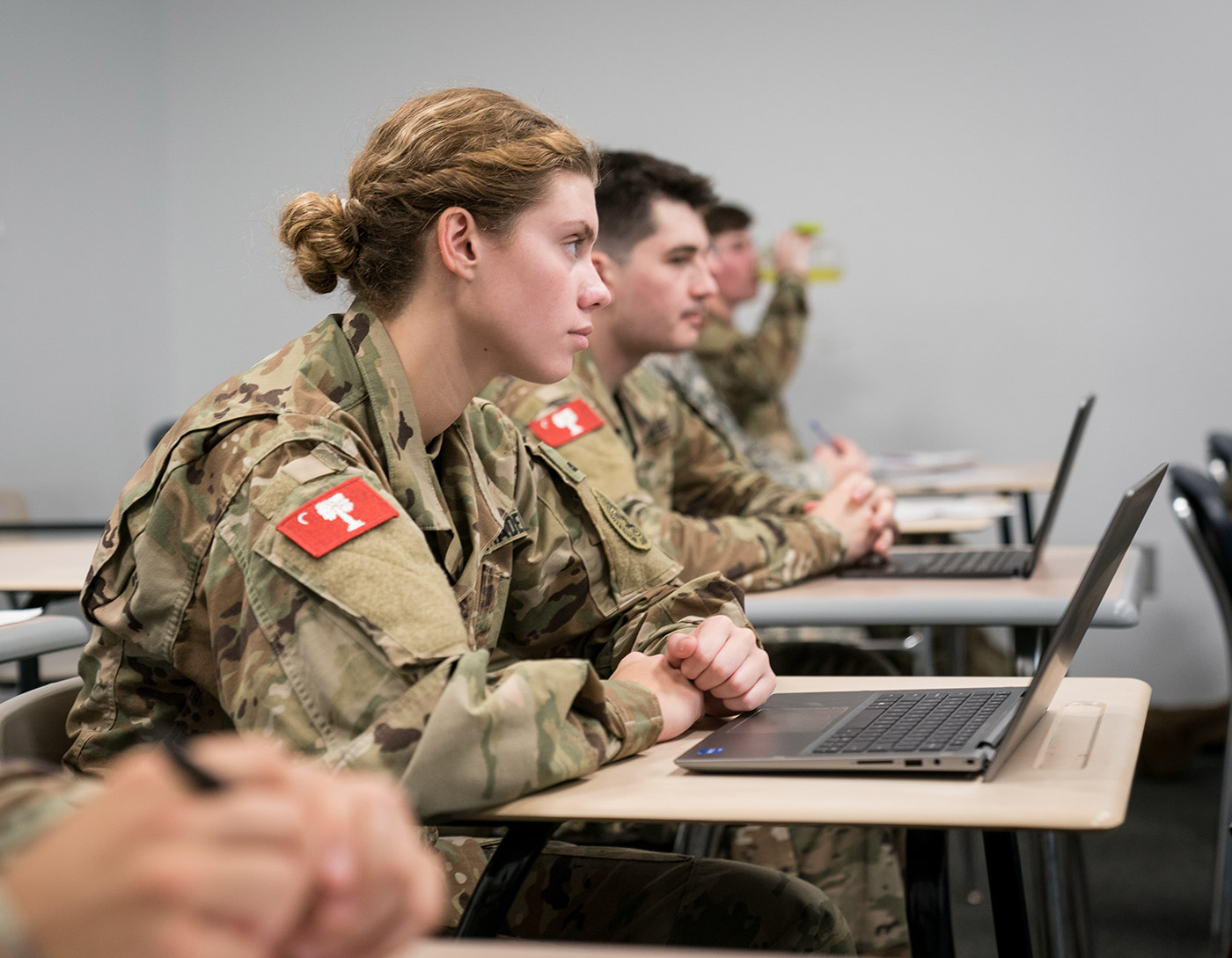 A picture of an honors program women student at her desk with a computer