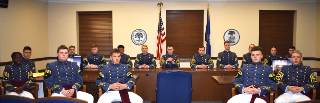Citadel cadets in dress uniforms seated in an honor court hearing room.