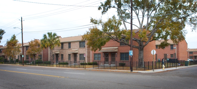 Exterior of a brick residential complex along a city street.