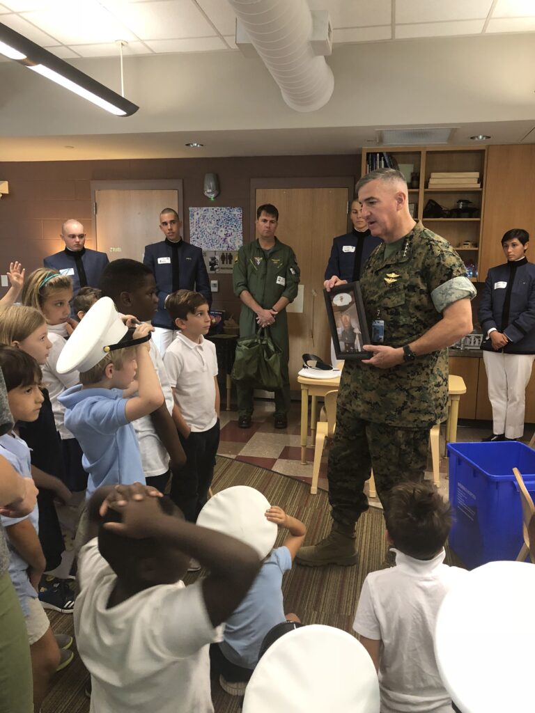 General Walters speaks with a group of schoolchildren while Citadel cadets and another service member observe.