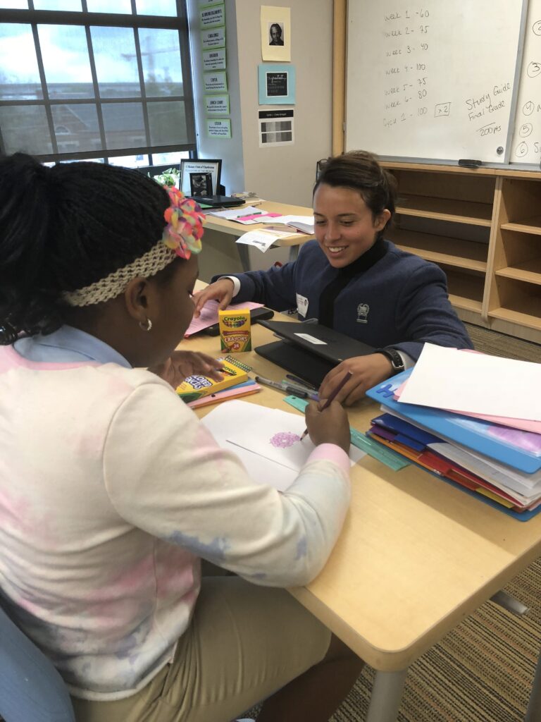Citadel cadet helps a student with a classroom activity.