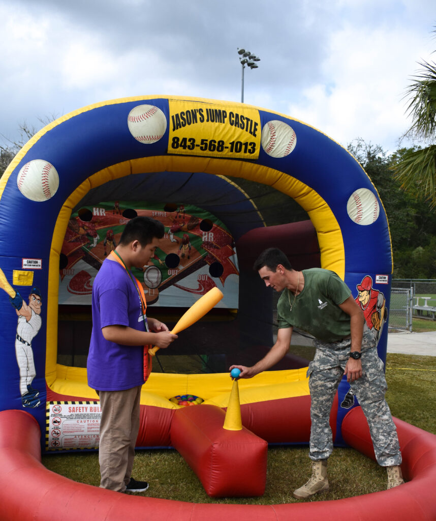 Citadel cadet and another participant prepare to play an inflatable baseball game during Leadership Day.