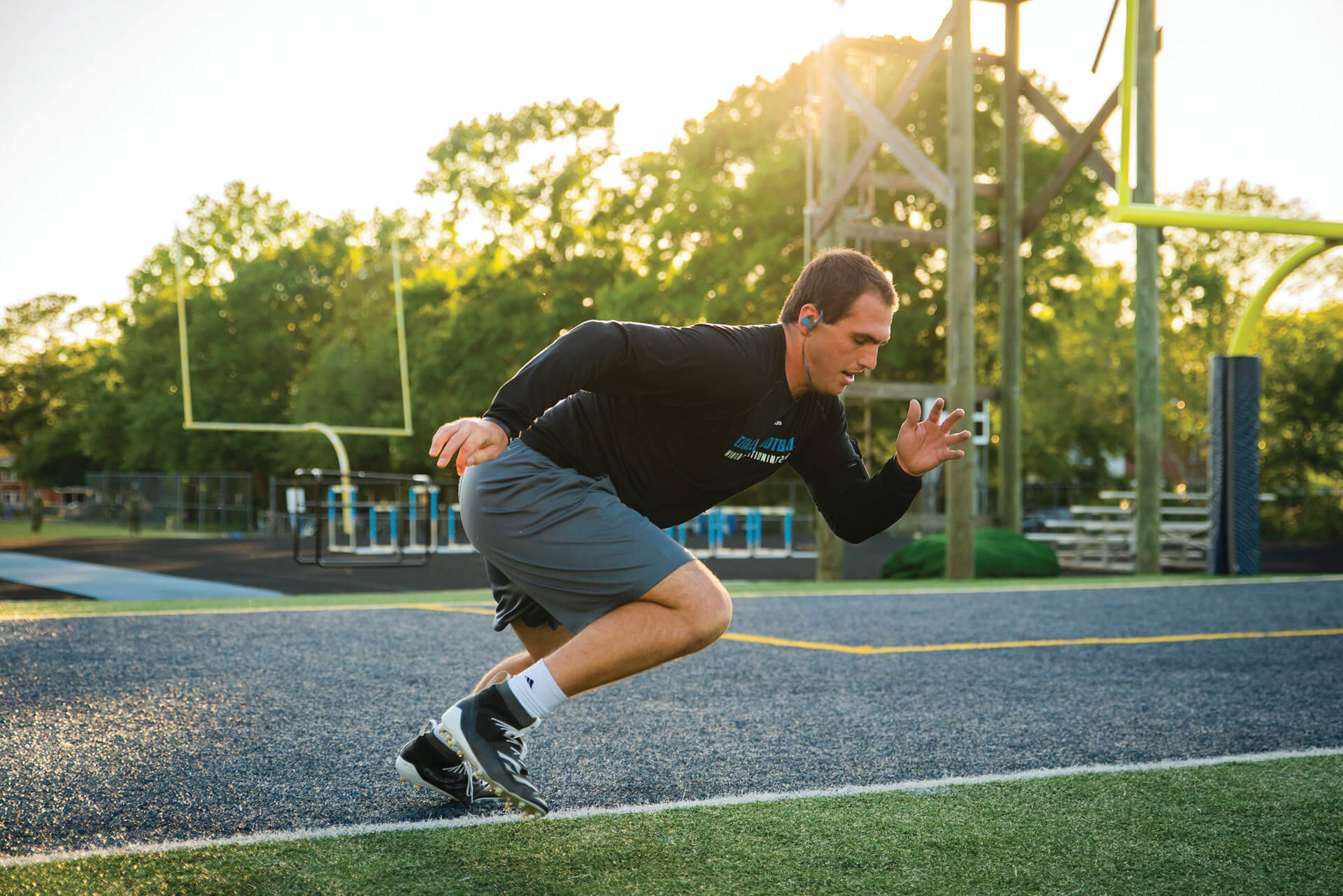 Man sprinting on an outdoor athletic field during a workout.