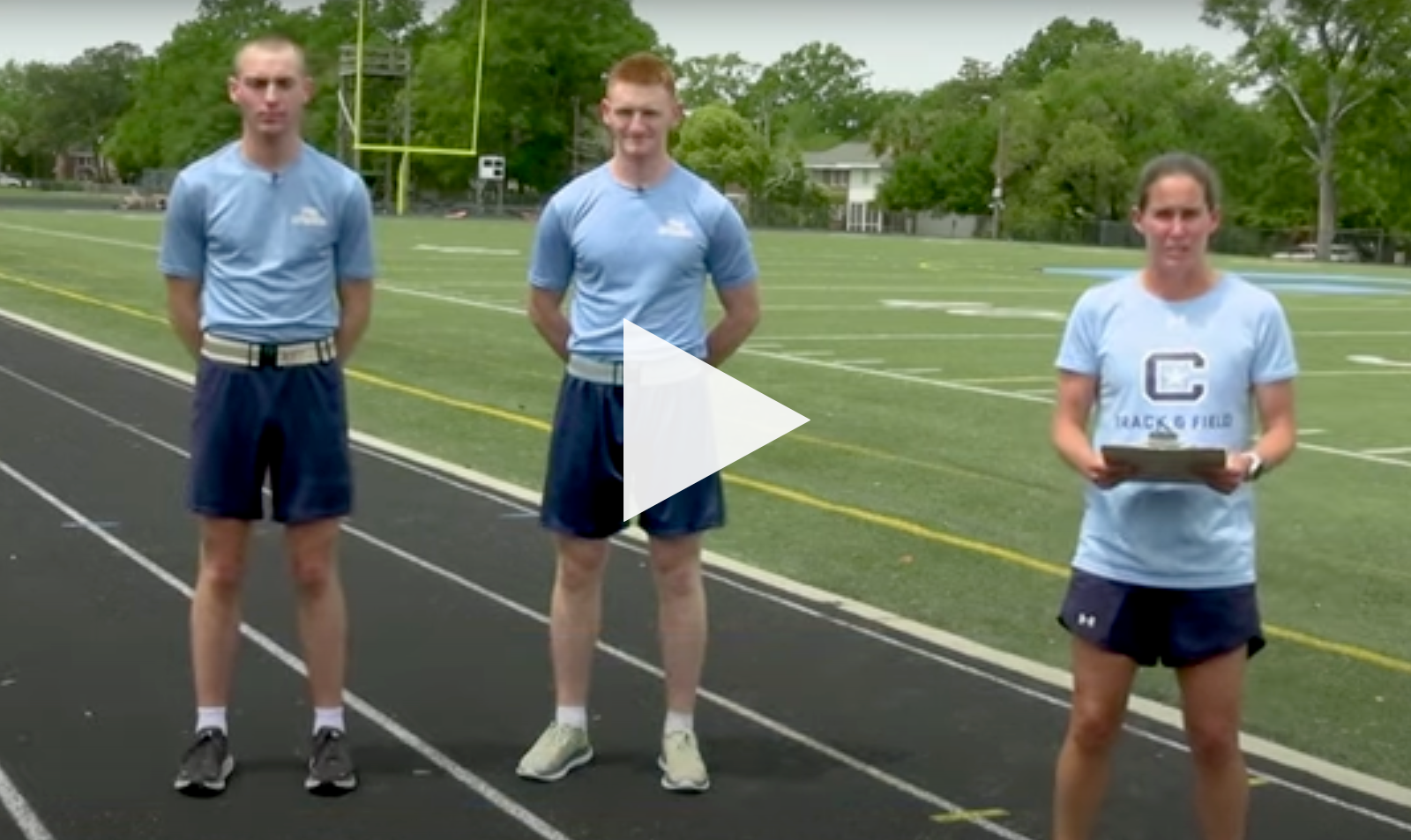 Three people stand on an outdoor track during a track and field instructional video.