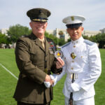 Retired Marine Corps Col. Thomas J. Gordon, '91, commandant of cadets, presents Cadet Kyle O’Grady with the Star of the West award on the parade field.