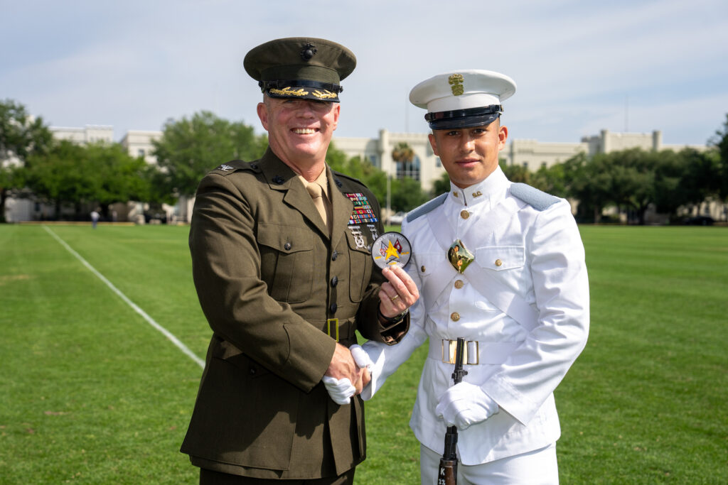 Retired Marine Corps Col. Thomas J. Gordon, '91, commandant of cadets, presents Cadet Kyle O’Grady with the Star of the West award on the parade field.