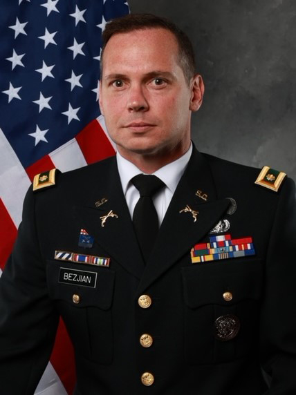 Professional portrait of Business Professor James Bezjian, Ph.D., wearing his dress military uniform with the U.S. flag in the background.