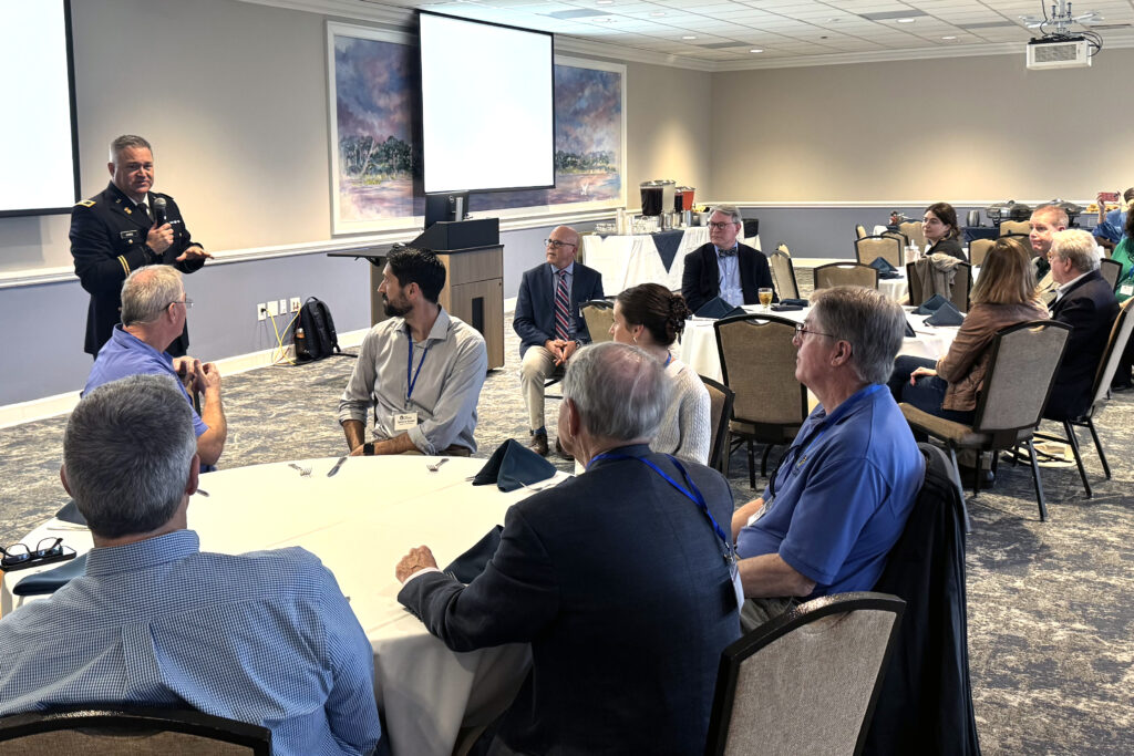 Brian Jones, Ph.D., dean of the School of Humanities and Social Sciences, speaks to attendees seated around tables during the Symposium on Southern Politics.