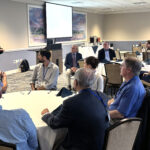 Brian Jones, Ph.D., dean of the School of Humanities and Social Sciences, speaks to attendees seated around tables during the Symposium on Southern Politics.