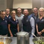 Faculty members from the Baker School of Business pose in the kitchen of the Ronald McDonald house.