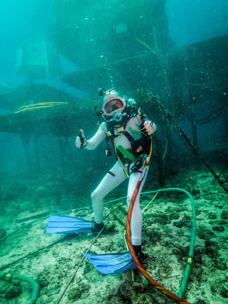 Randy Bresnik gives two thumbs up while wearing diving equipment underwater during a NEEMO mission.