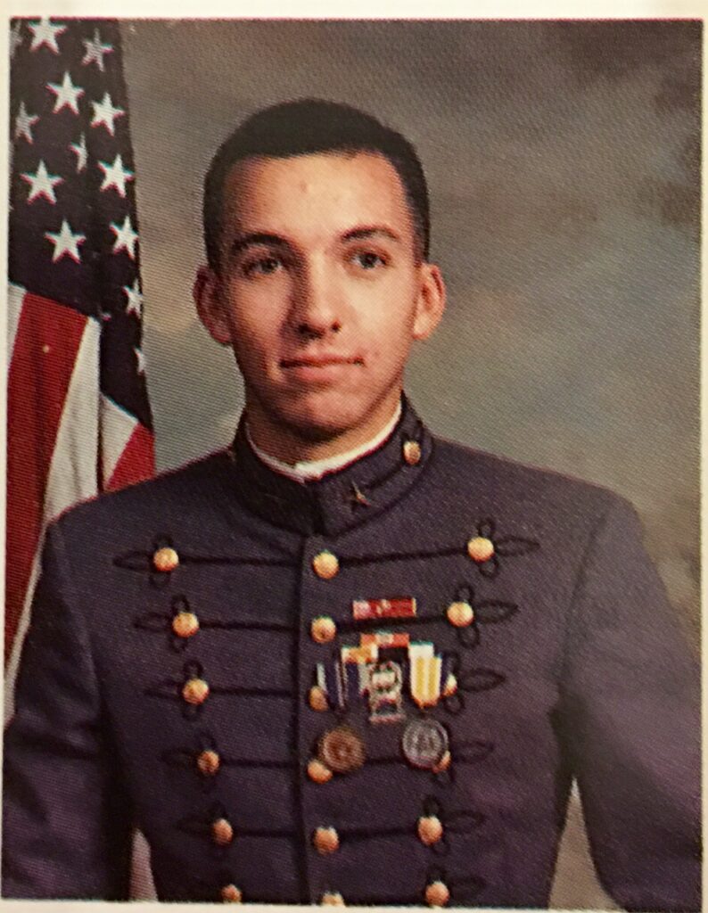 Cadet Randy Bresnik poses in his Citadel uniform with an American flag in the background.