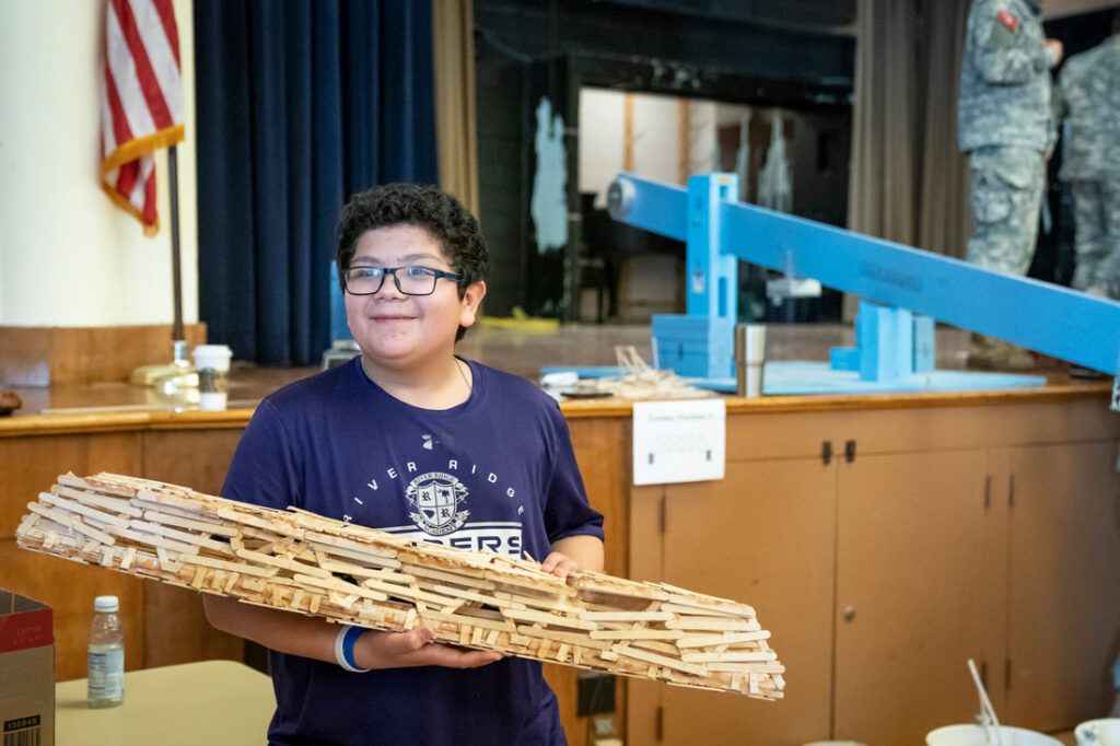A STEM Competition participant with a constructed bridge